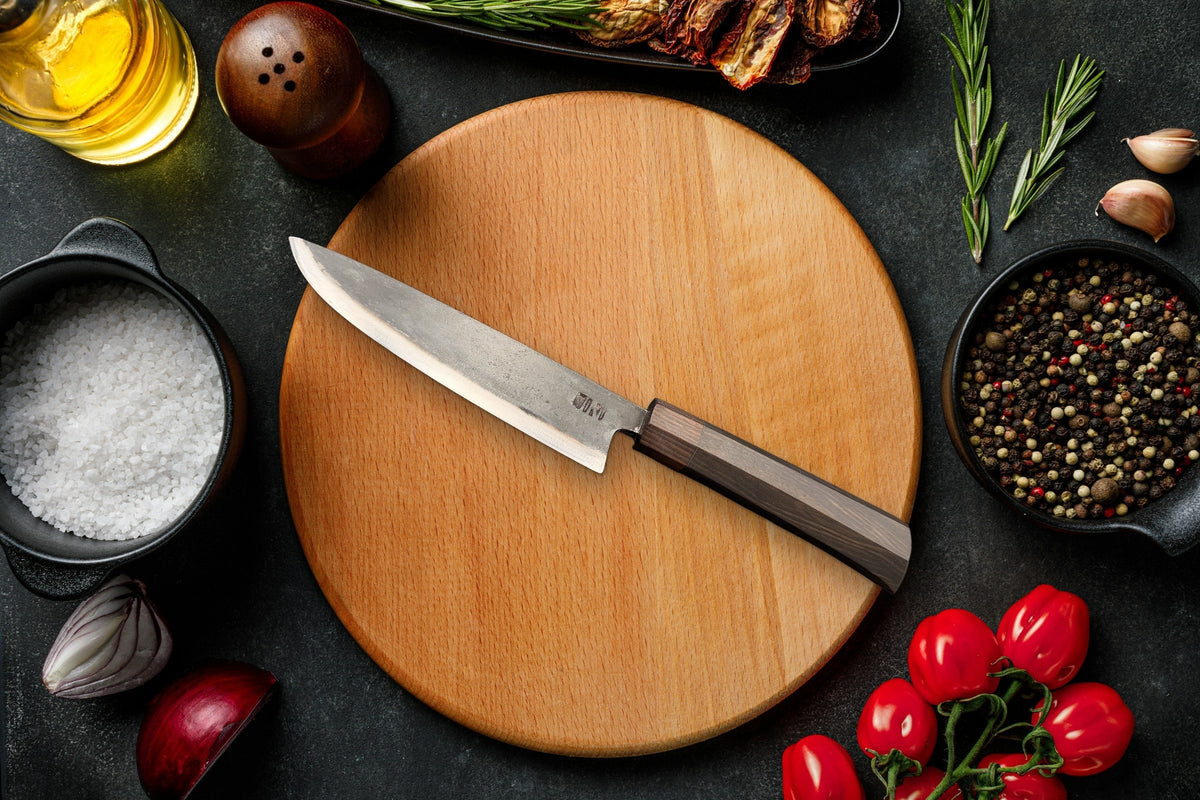 Couteau Cuisine Gyuto Forge Tay, finition carbone noir, sur planche ronde