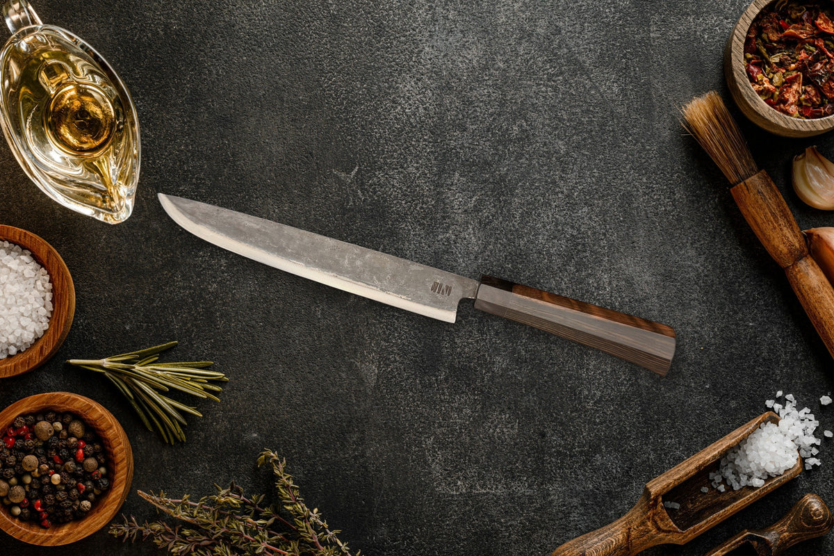 Couteau Fish trancheur Forge Tay, finition carbone noir, sur ardoise